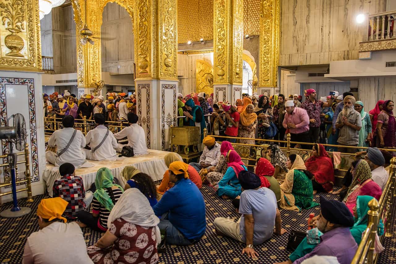 Sikh people are sitting and praying in the Gurudwara Bangla Sahib