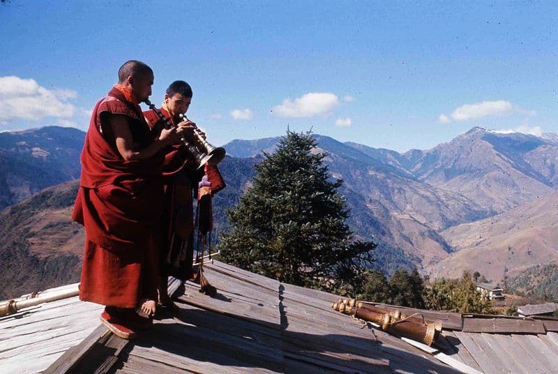 monks play music on the roof of the Chiwong Gompa