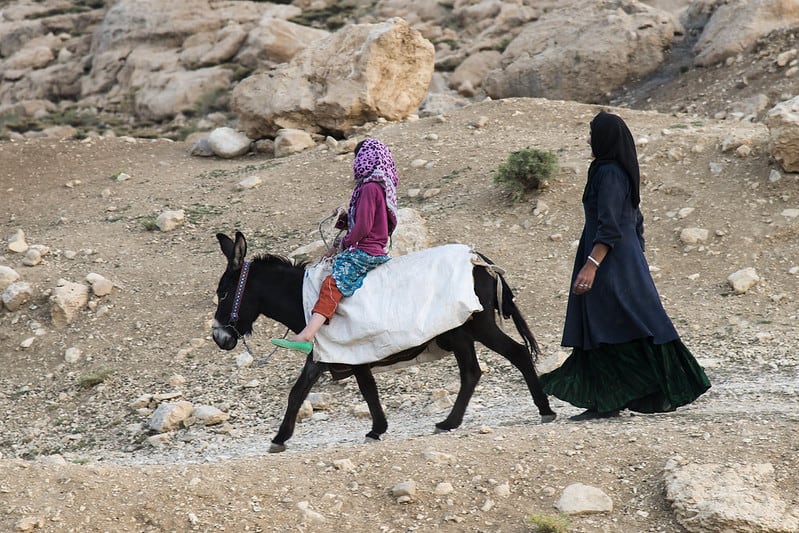 nomad mother and her daughter riding a donkey in Iran