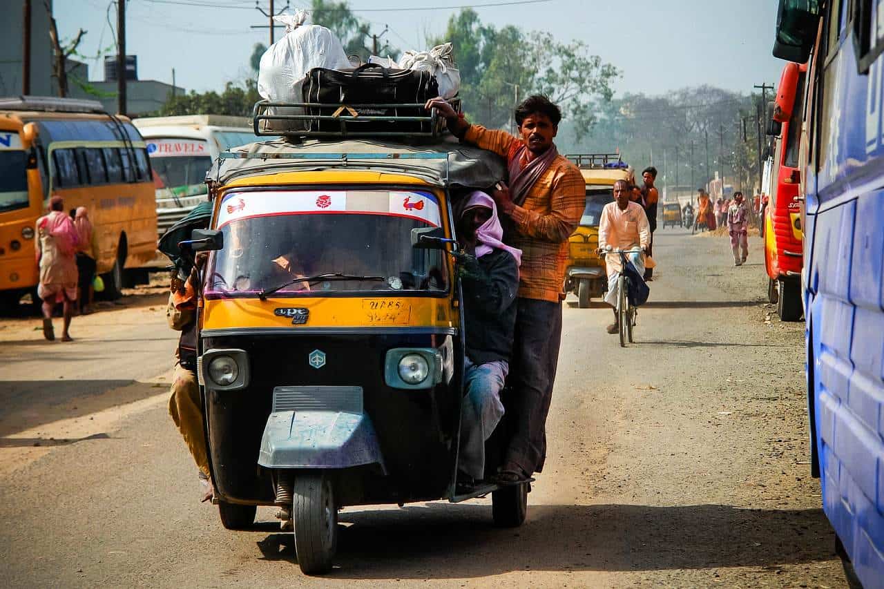 People traveling with a rickshaw in India