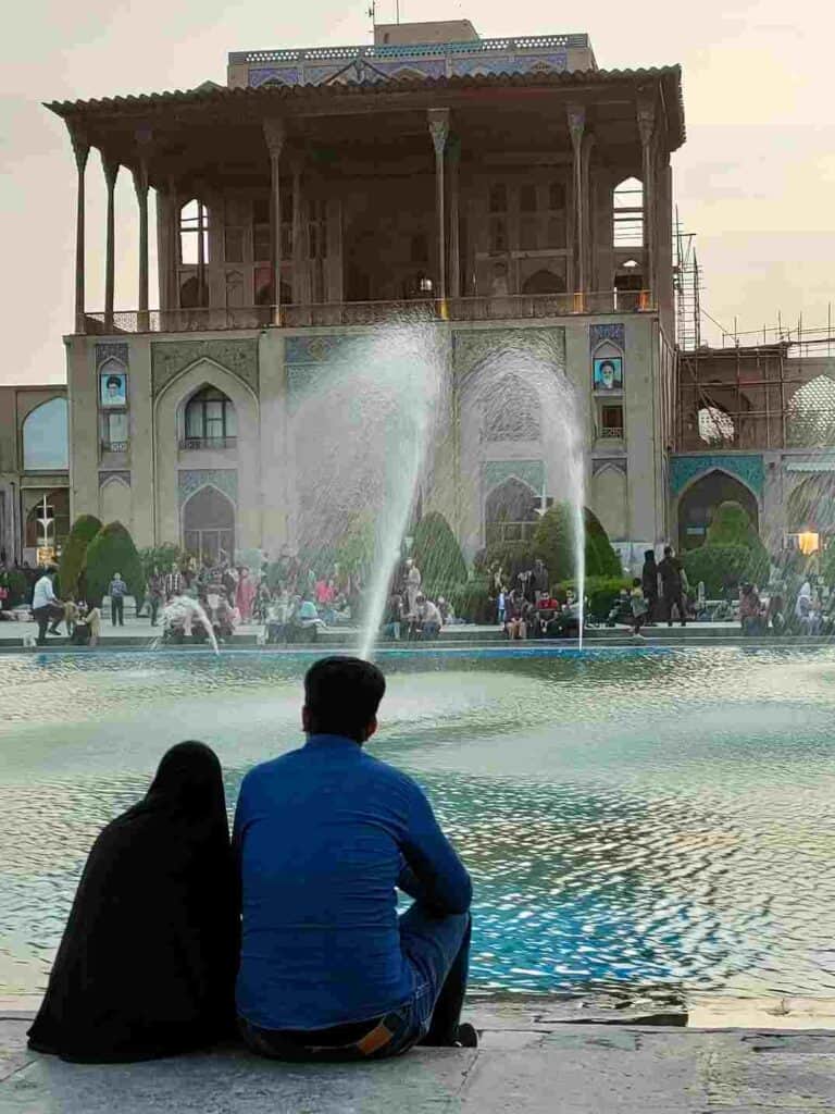 Iranian couple sitting near Ali Qapu palace in Isfahan