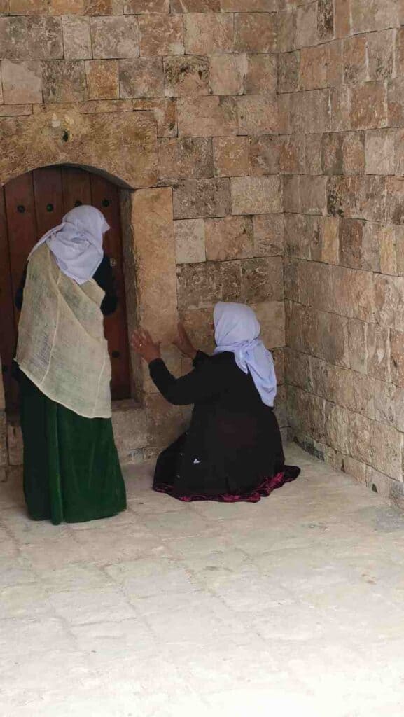 Two yezidi women are praying in lalish, Iraqi Kurdistan
