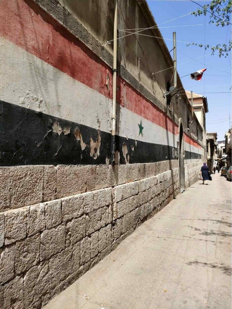 Damascus old city with graffiti of Syrian flag 